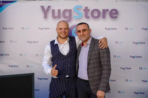 Гости фотографируются у баннера «YugStore — 15 лет»